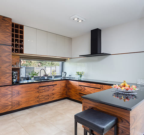 Nowoczesna kuchnia z drewnianymi frontami i wyspą.